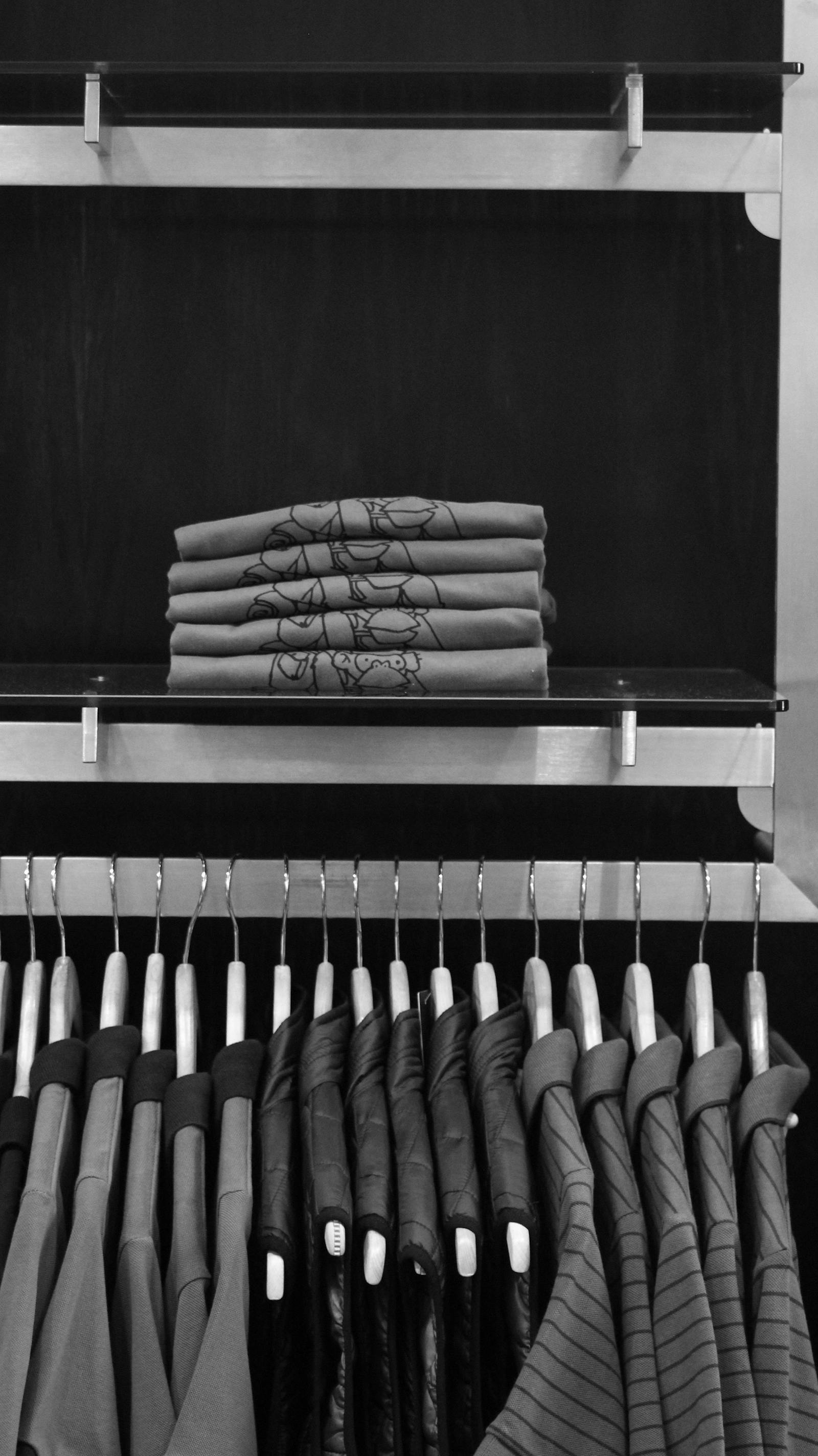 Fotografía representativa de ropa doblada y prendas en exhibición.
